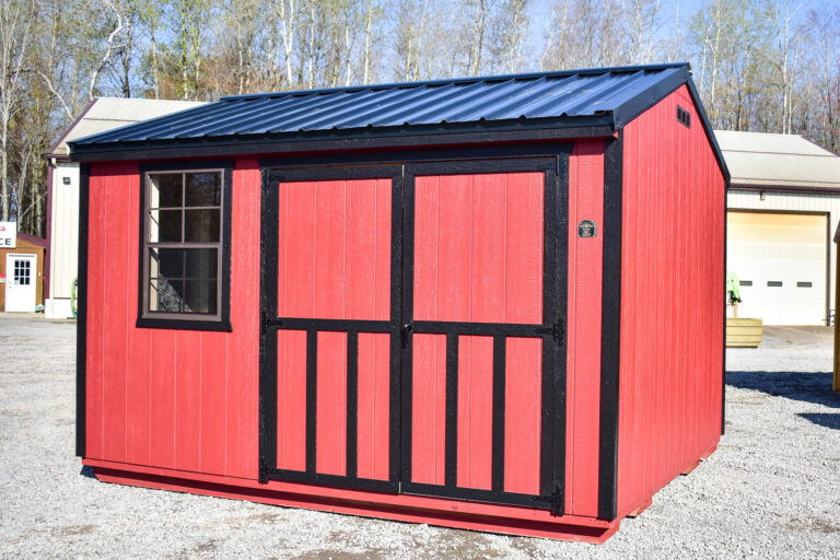 This 10x12 utility shed features a striking red-painted exterior with black trim, double doors in the front with decorative crossbuck styling, and a black metal roof. It includes a window on the left side for natural light and is ideal for storage or workspace use.