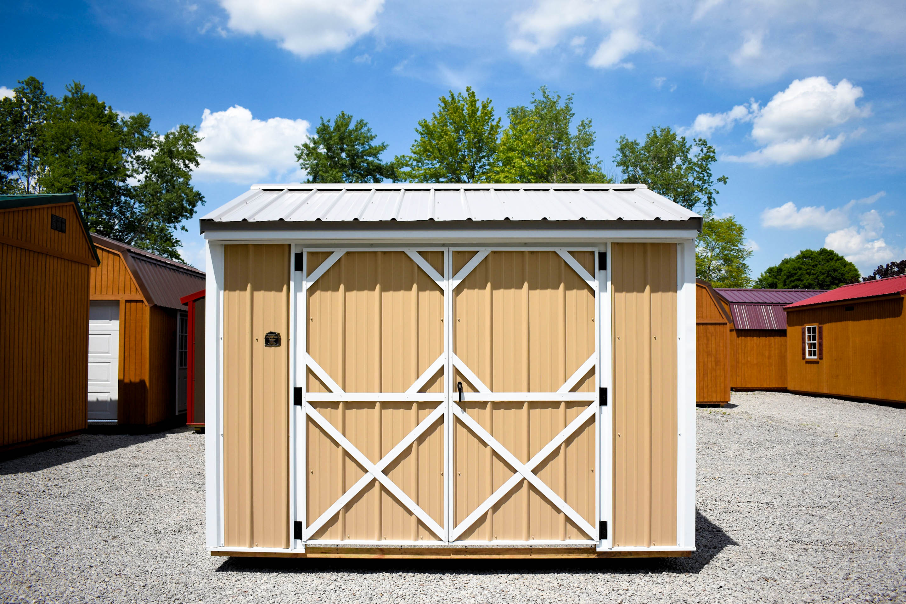 Small tan metal Garden Shed with a white metal roof