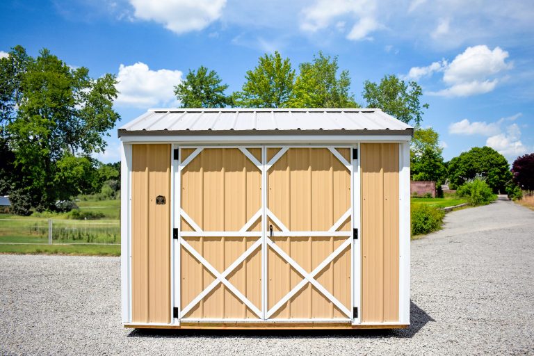 Garden shed with tan metal siding and white metal roof
