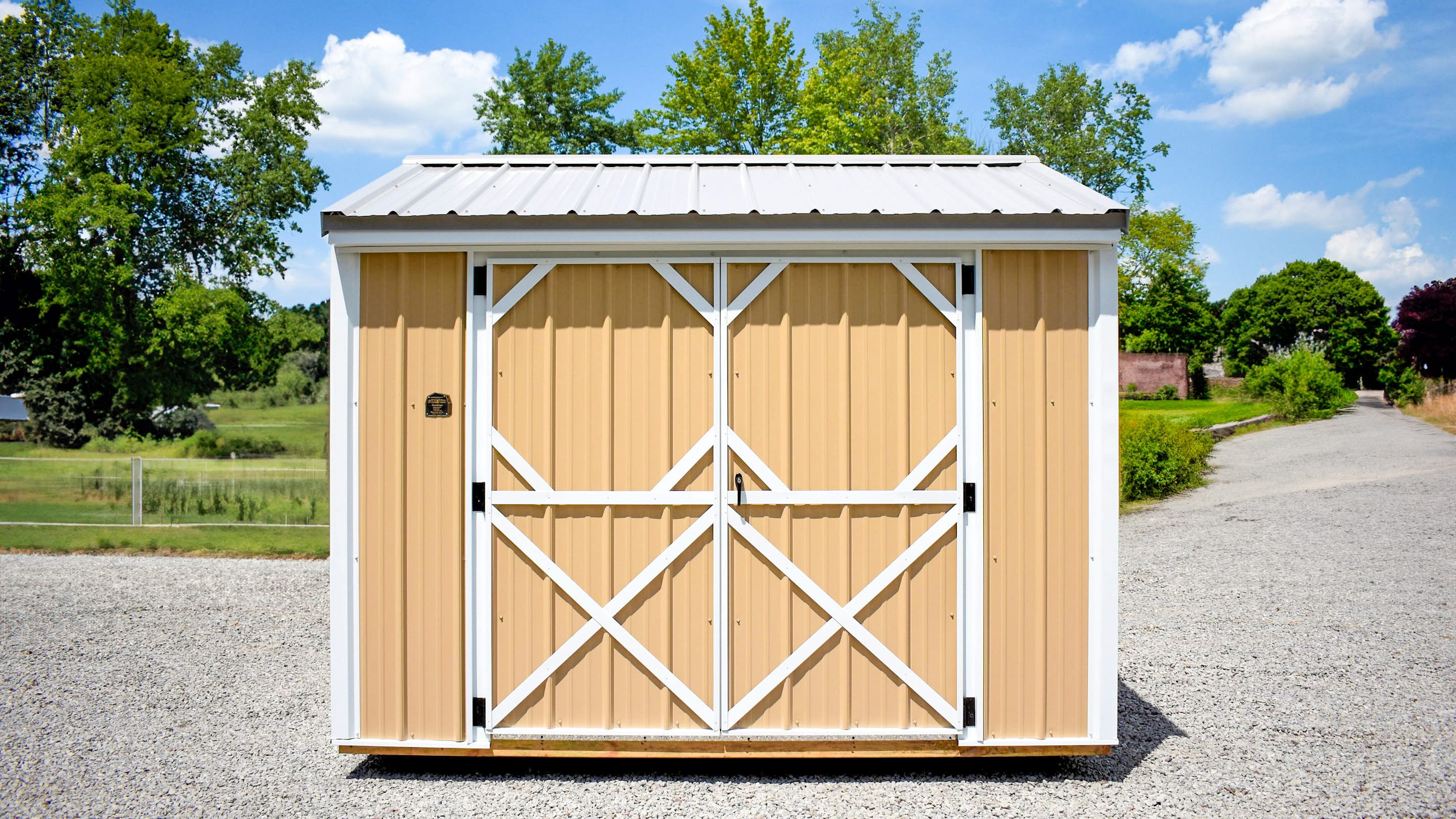 Garden shed with tan metal siding and white metal roof