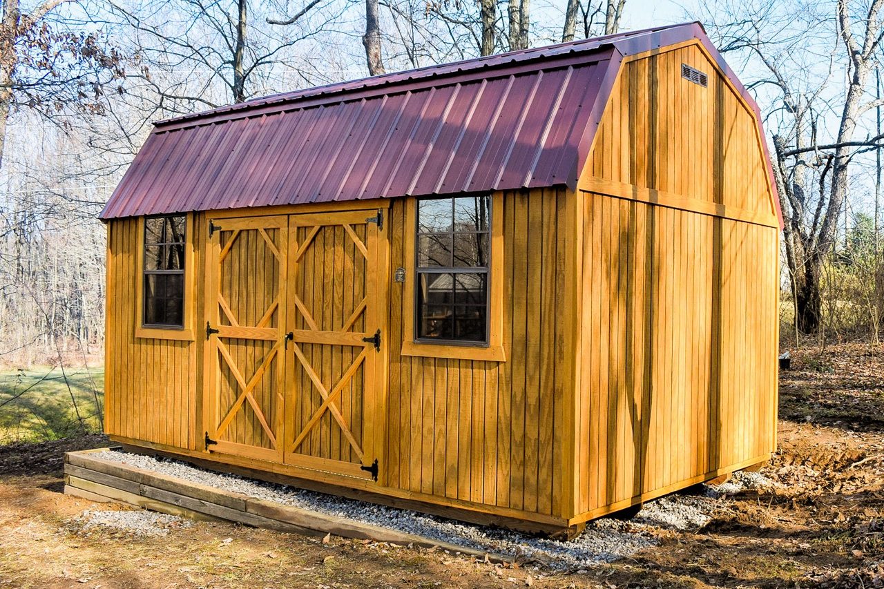 Lofted wood garden shed with red metal roof and double doors